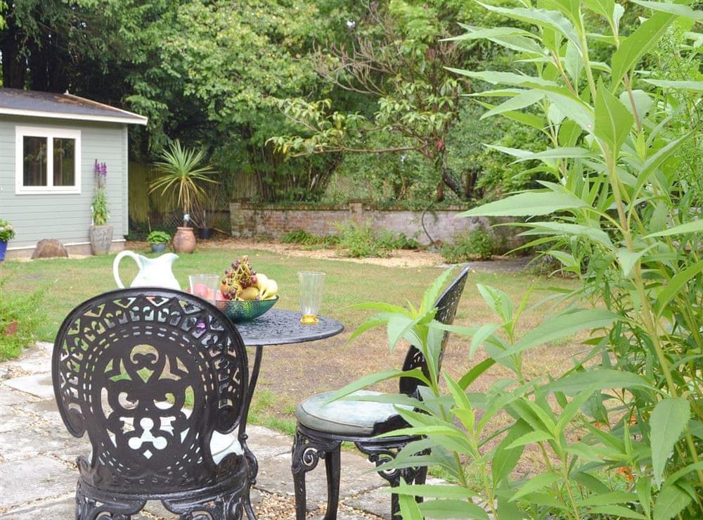 Patio area and lawned garden at Arnewood Corner in Sway, near Lymington, Hampshire