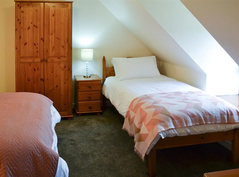 Bedroom with double and single beds at Arnish Cottage in Uigshadder near Portree, Isle Of Skye
