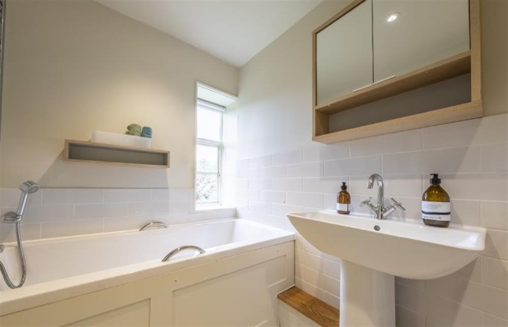 Family bathroom with bath and hand-held shower at Art Farmhouse, Saxmundham