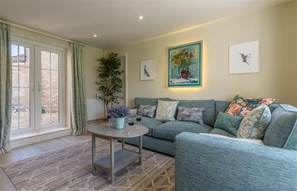 Ground floor: Large corner sofa and french doors in the Sitting room at Ashdale, Thornham near Hunstanton