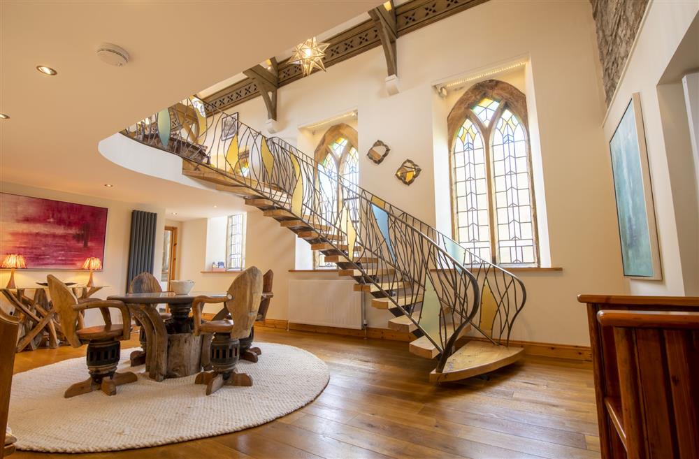 Entrance hallway with table and seating for four guests, with spectacular wrought iron staircase at Askrigg Chapel, Askrigg, North Yorkshire