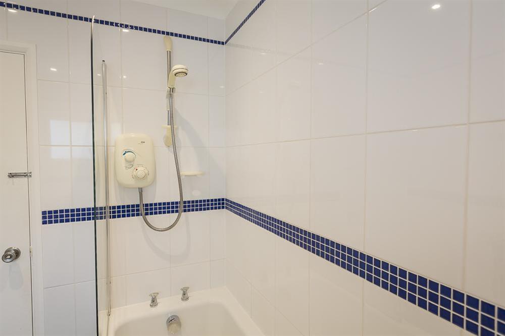 Family bathroom featuring bath and power shower at Atlantic Lodge in Hope Cove, Kingsbridge