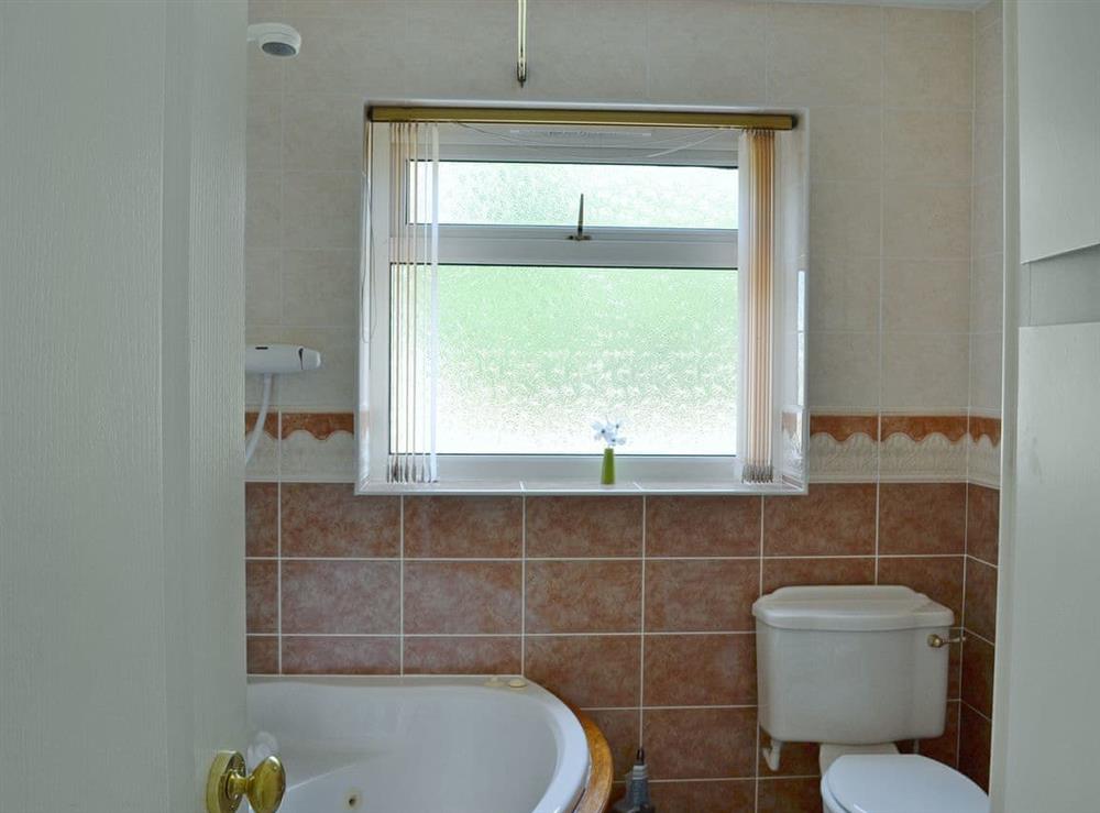 Bathroom with shower over spa bath at Authorpe Bungalow in Hogsthorpe, near Skegness, Lincolnshire