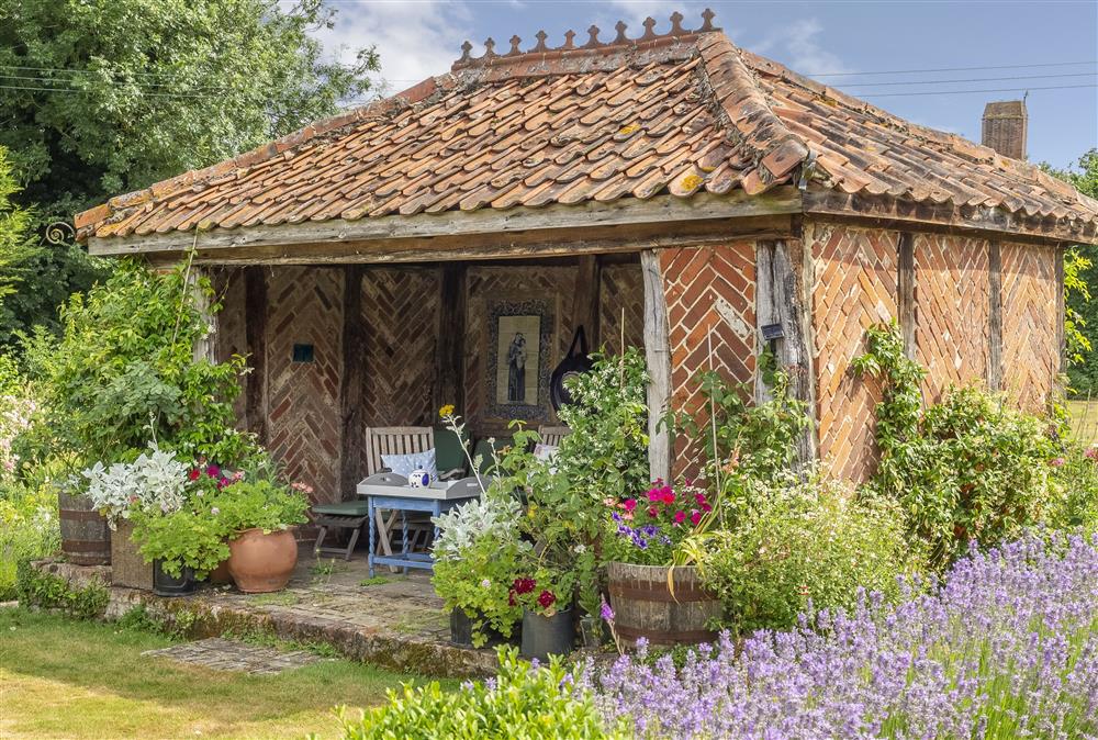 The medieval-style summer house has garden furniture to relax in at Ayres End Studio, Suffolk at Ayres End Studio, Kersey