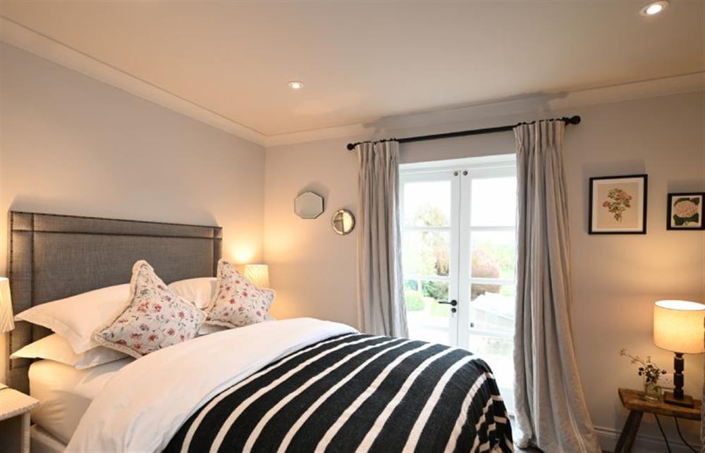 Bedroom five on the ground floor with a 5’ king-size bed with views over the terrace and garden