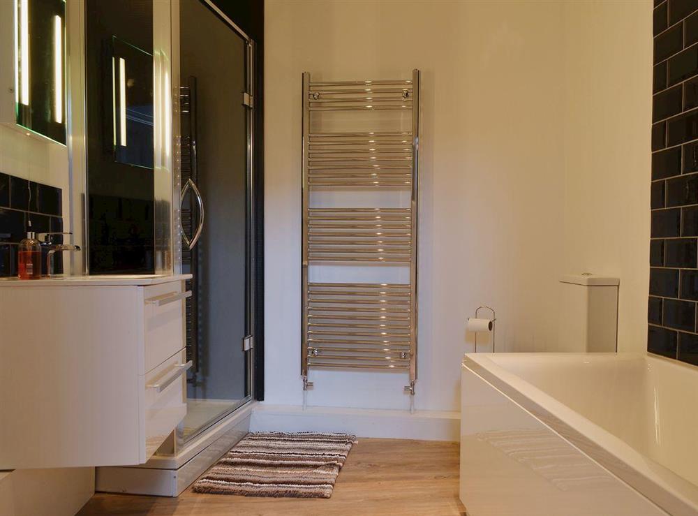 The stylish family bathroom has a shower, bath, wc, wash basin and a heated towel rail at Bag End in Keswick, Cumbria