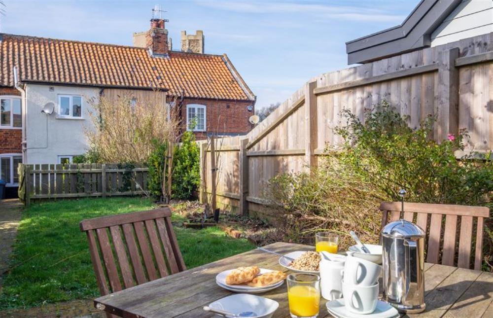 Rear garden with garden furniture and charcoal barbecue at Bailey Cottage, Orford