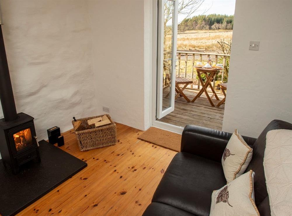 Cosy conservatory with wood burner at Balloan Farm Cottage in Lairg, Highlands, Sutherland