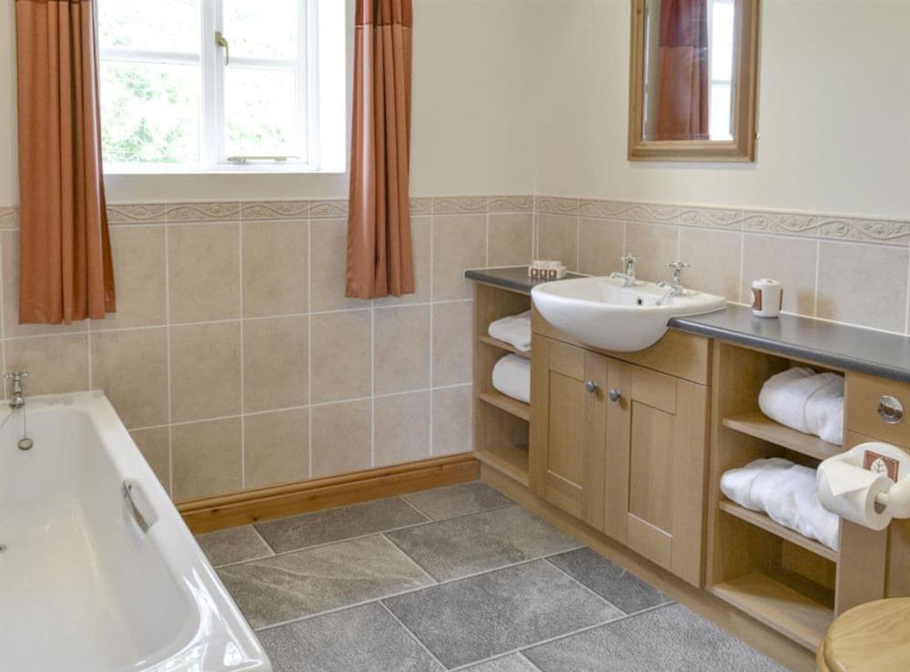 En-suite bathroom with bath and separate shower cubicle at Bank Top Cottage in Pickering, North Yorkshire