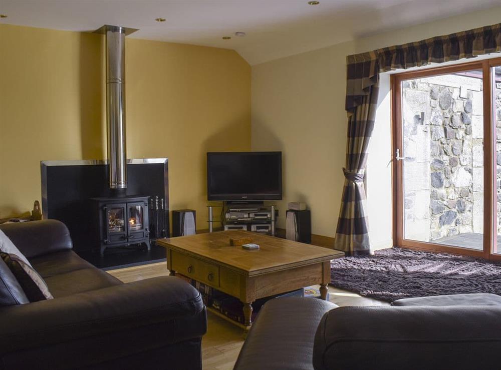 Well presented living room with wood burner at The Byre,