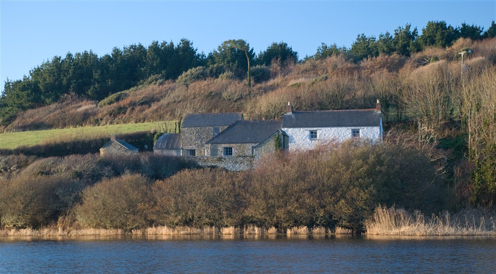 A view of Degibna Lower Pentire Farm House from across Loe Pool, Cornwall at Bar Lodge in Helston, Cornwall