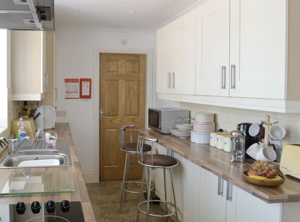 Galley-style kitchen with breakfast bar at Barkers Cottage in Ellington, near Druridge, Northumberland