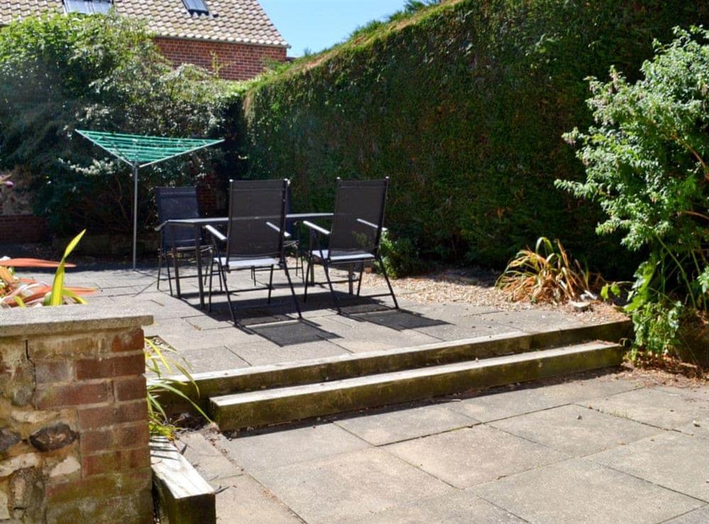 Paved, south-facing garden with patio at Barmstone Cottage in Brancaster, Norfolk., Great Britain