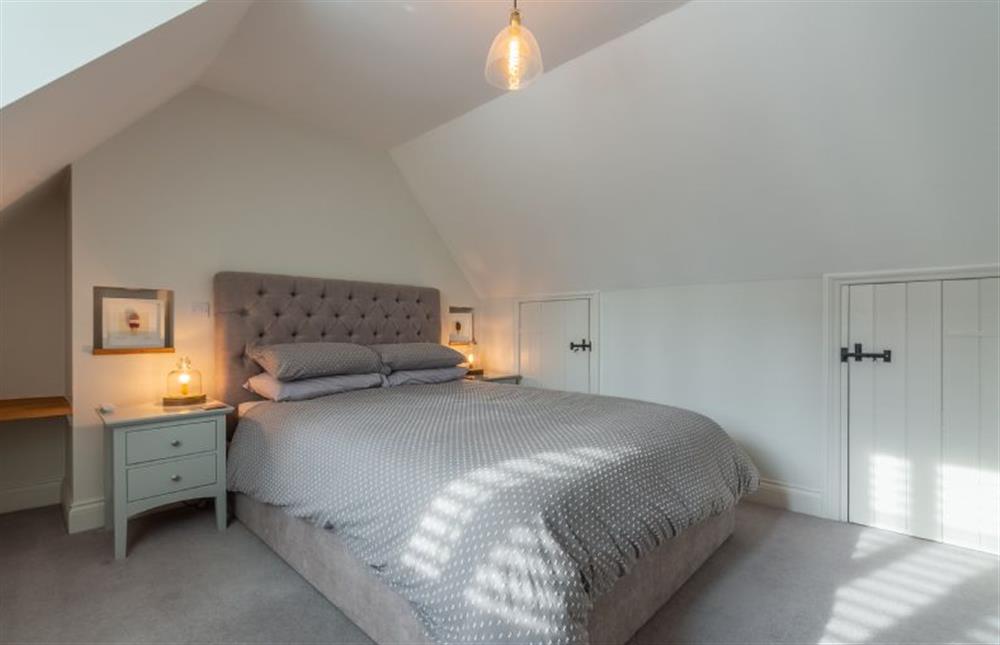 First floor: Bedroom two with king-size bed and views over the garden at Barn Cottage, Salthouse near Holt