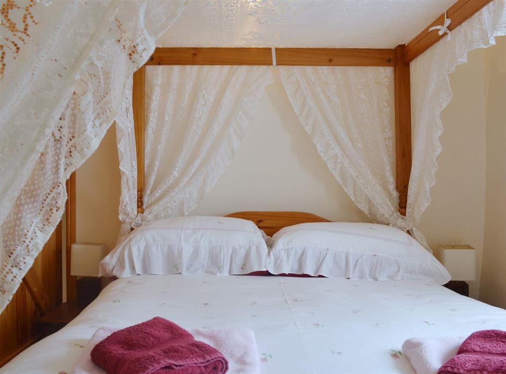 Relax in comfort in the charming four poster bedroom at Barn Owl Cottage in Matlock, Derbyshire