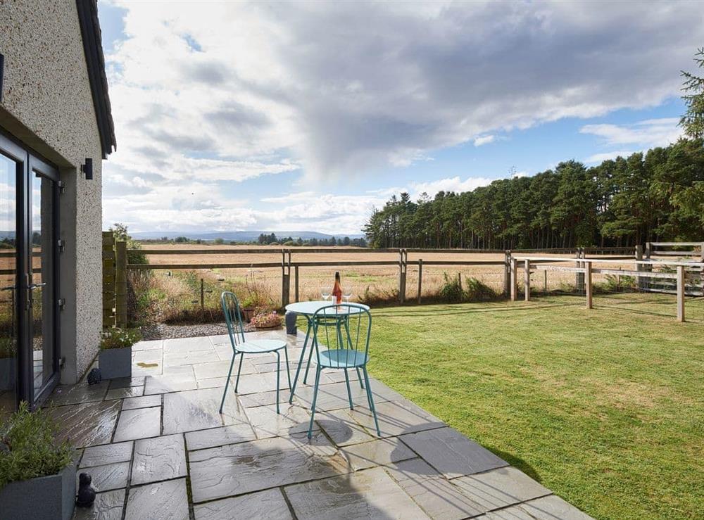Paved patio and lawned garden at Barn Owl Cottage in Newton, near Tain, Highlands, Ross-Shire