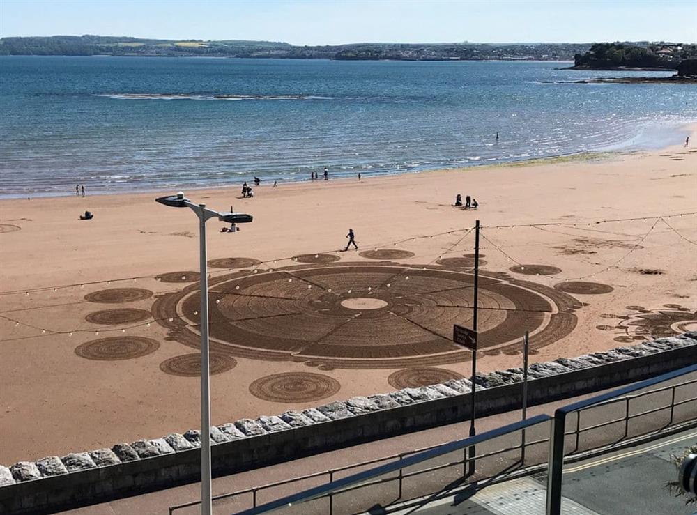 Sand artist viewed from the balcony at Bay View in Torquay, Devon