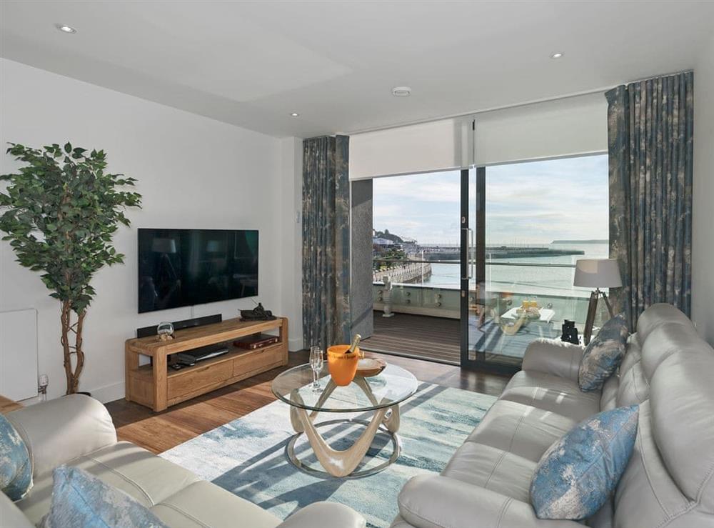 Tastefully furnished living area with patio doors leading to balcony at Bay View in Torquay, Devon