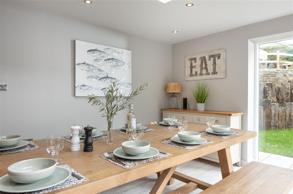 Beach Cottage, Cornwall: Dinning area with a large bench style dining table for eight guests, Bluetooth speaker and double french doors to garden