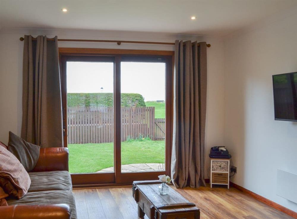 Living room with patio doors to the garden at Beach House in Nairn, Highlands, Morayshire
