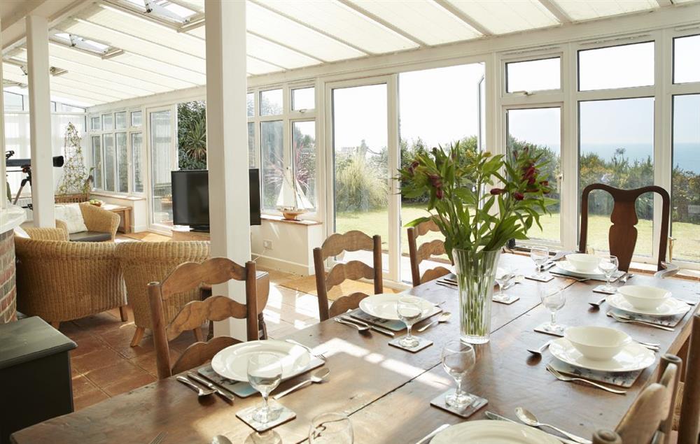 Dining table in the conservatory seating eight guests and seating area at Beach View, Southbourne