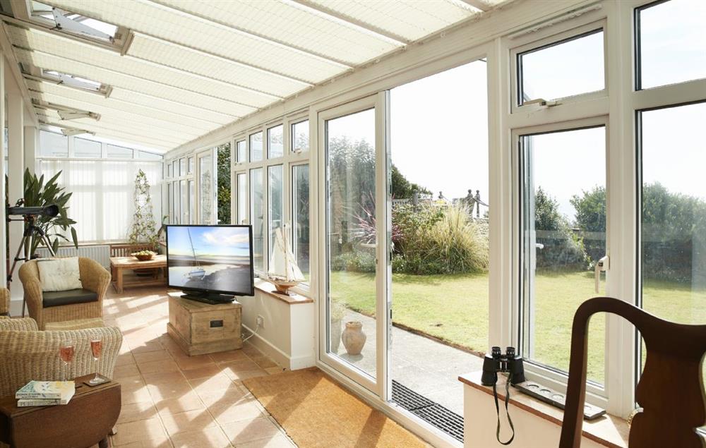 The spacious conservatory with dining table and further seating at Beach View, Southbourne