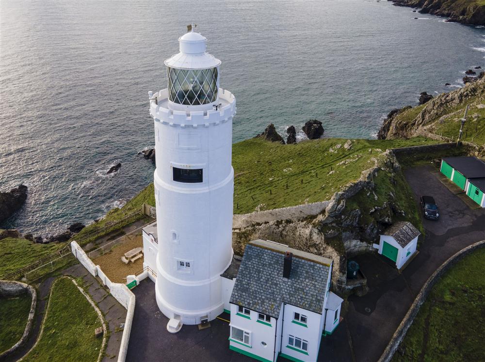 An aerial view of the light house shows off its dominant positioning at the end of the headland   at Beacon Cottage, Start Point Lighthouse