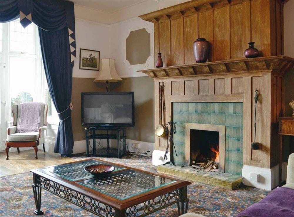 Cosy living room with open fire at Beaford House in Beaford, near Winkleigh, Devon