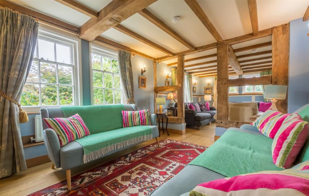 L-shaped sitting room with open log fire in House at Bearwood House and Cottage, Pembridge, near Leominster