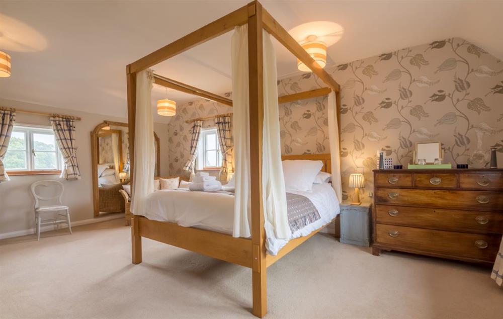 Master bedroom with 5’ four-poster bed and en suite bathroom at Bearwood House, Pembridge