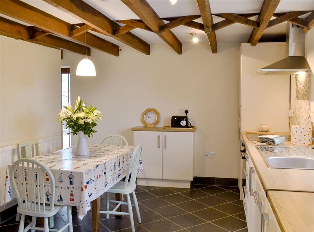 Kitchen/ dining room with beamed ceiling and slate floor at Beckaveans Granary, 