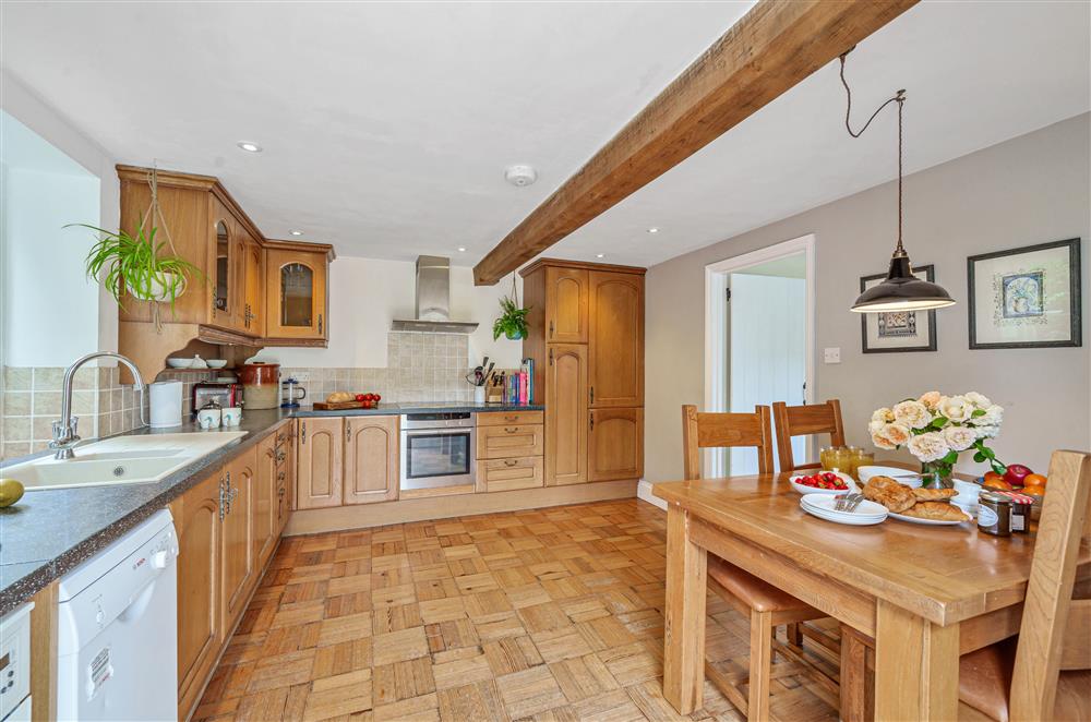The original floor and beams add character to the open-plan kitchen and dining area at Beech Cottage, Honiton