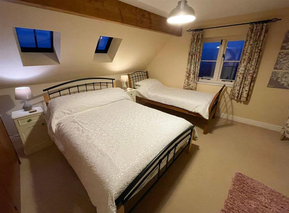 Family bedroom with a double and a single bed (photo 2) at Beech Cottage in Llanrhaeadr, near Denbigh, Denbighshire