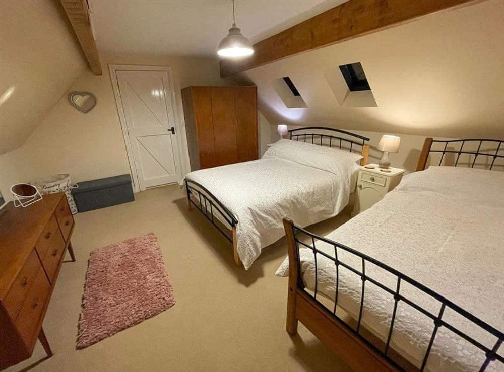 Family bedroom with a double and a single bed at Beech Cottage in Llanrhaeadr, near Denbigh, Denbighshire