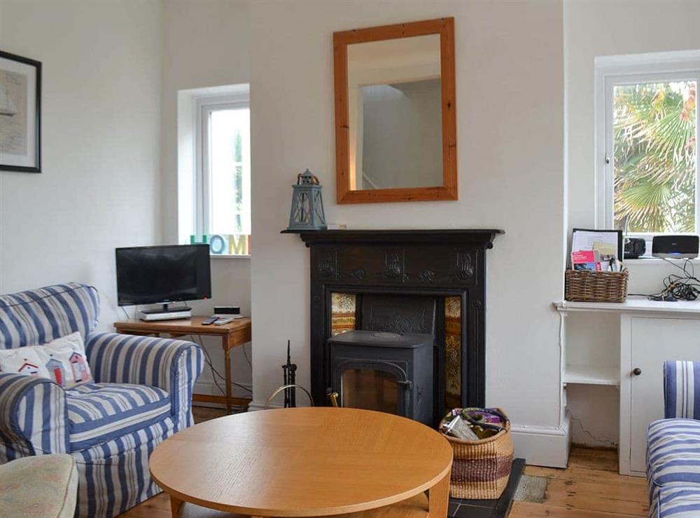 Living room with woodburner and open fireplace at Beech Cottage in St Lawrence, near Ventnor, Isle of Wight