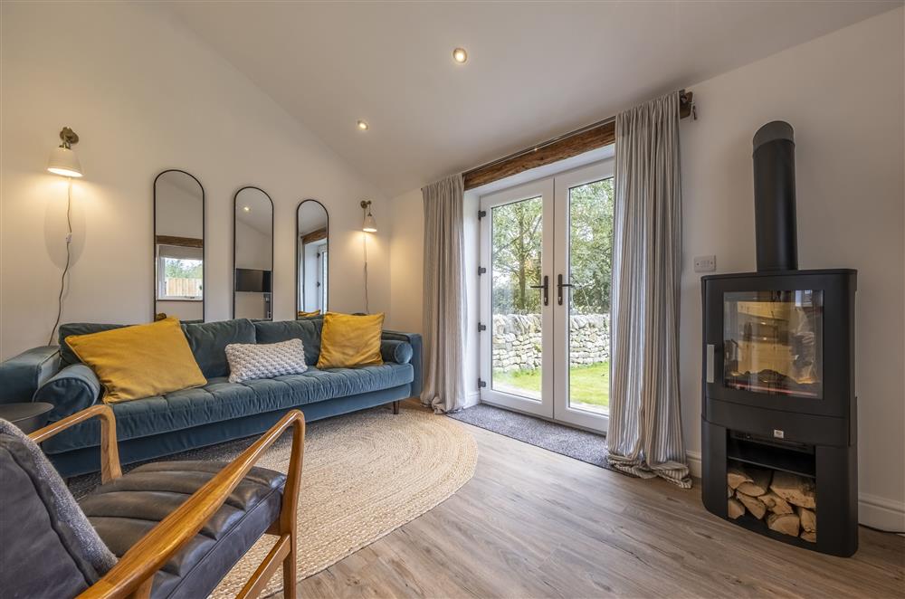 The cosy sitting room boasts a wood burning stove  at Beech Farm Barns, Buxton