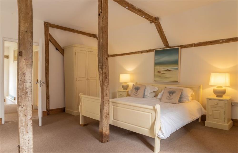 Bedroom one with exposed beams at Belchamp Hall Coach House, Belchamp Walter