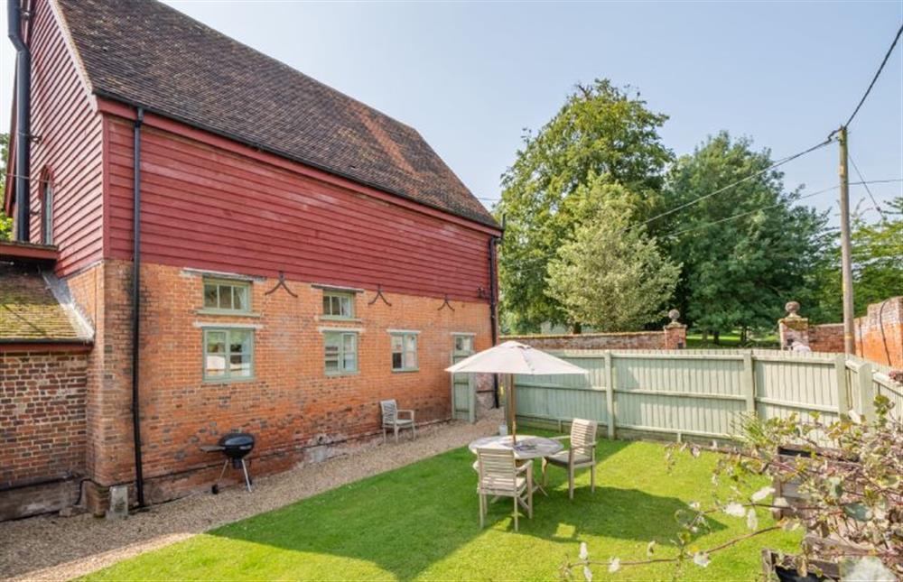 Garden with furniture and barbecue for guests to enjoy al fresco dining at Belchamp Hall Coach House, Belchamp Walter