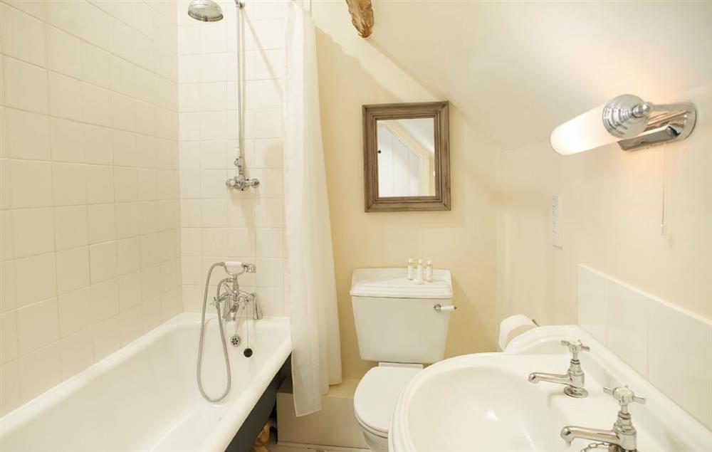 Family bathroom with roll top bath and shower over. at Benville Cottage, Benville