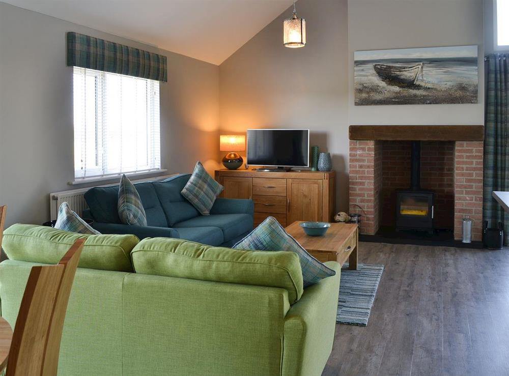 Open plan living space with wood burner at Bernicia Sands in Beadnell, near Seahouses, Northumberland