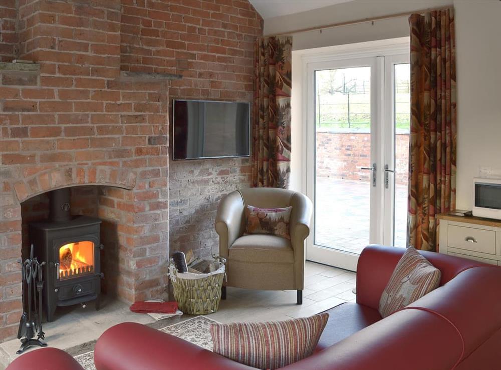 Cosy living area with wood burner at Carpenters Cottage, 