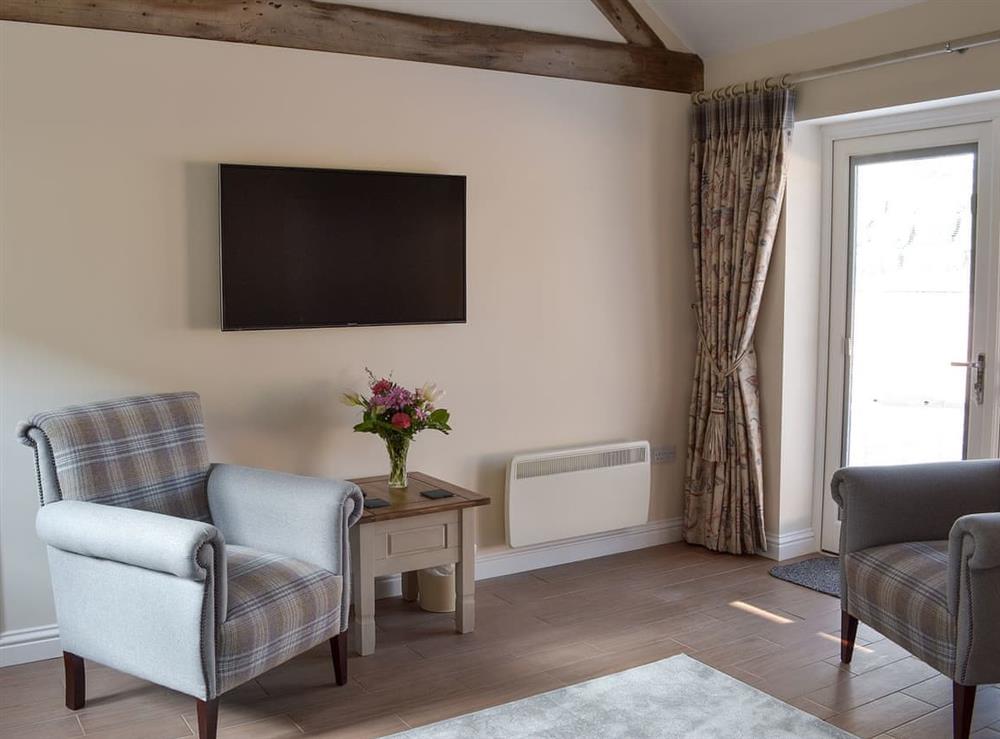 Living room with wall mounted TV at Woodside Cottage, 