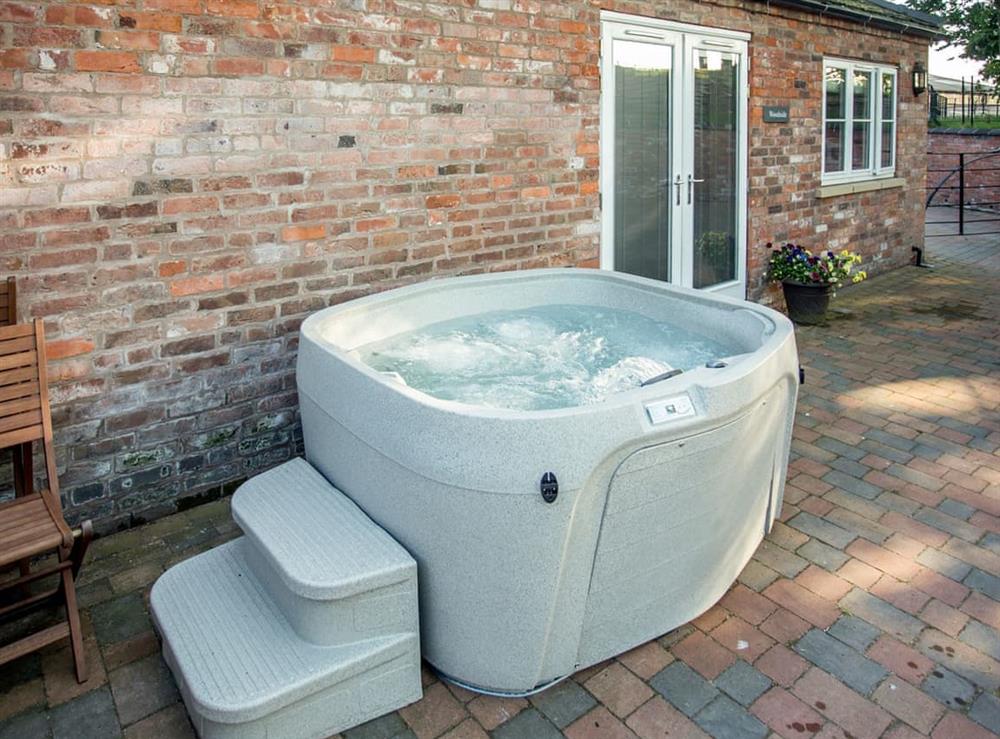 Luxurious private hot tub on patio at Woodside Cottage, 