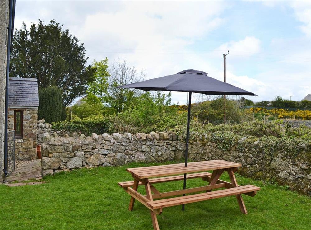 Enclosed lawned garden with garden furniture at Bettws y Gwynt in Llanbedrgoch, near Benllech, Anglesey, Gwynedd
