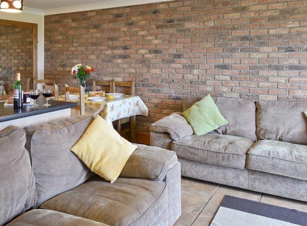Attractive lounge area of open-plan room at Bevan Cottage in Muston, Filey, North Yorkshire