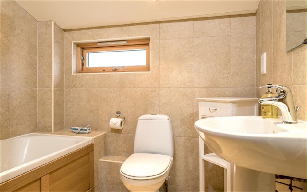 The spacious family bathroom at the front of the house has a bath, wc and hand basin. at Birch Cottage in Falmouth
