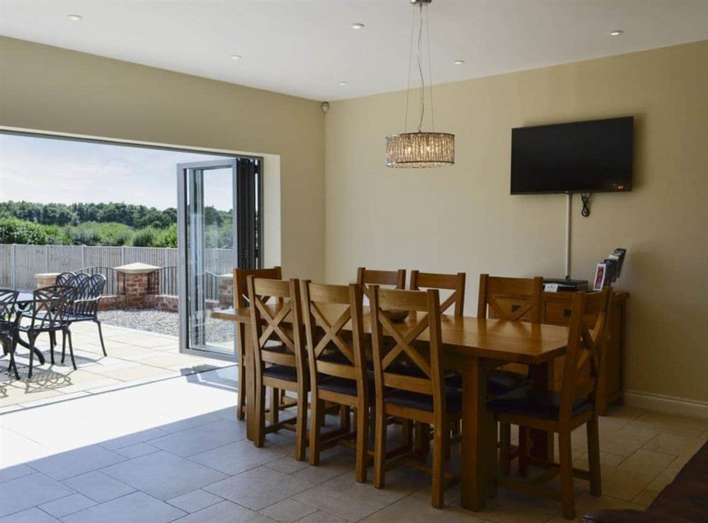 Dining room/kitchen with breakfast bar, TV, tiled floor and bi-fold doors to patio (photo 4) at Birchfield in Rhuallt, near St Asaph, Denbighshire