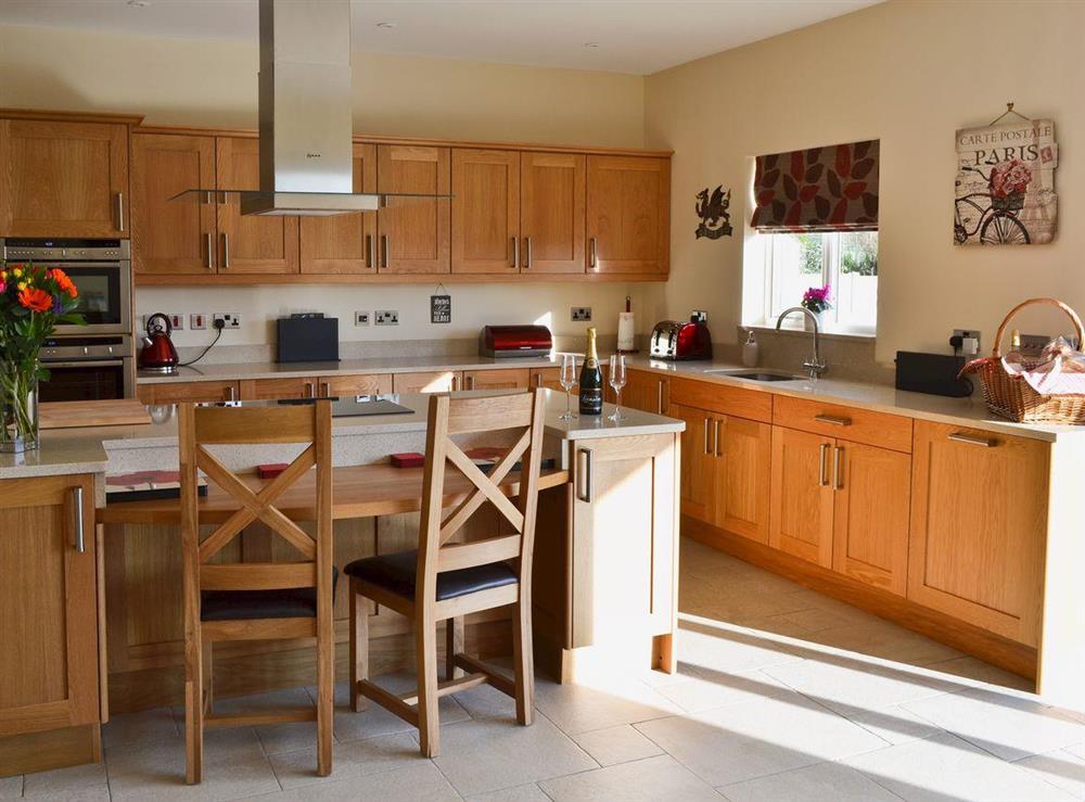 Dining room/kitchen with breakfast bar, TV, tiled floor and bi-fold doors to patio at Birchfield in Rhuallt, near St Asaph, Denbighshire