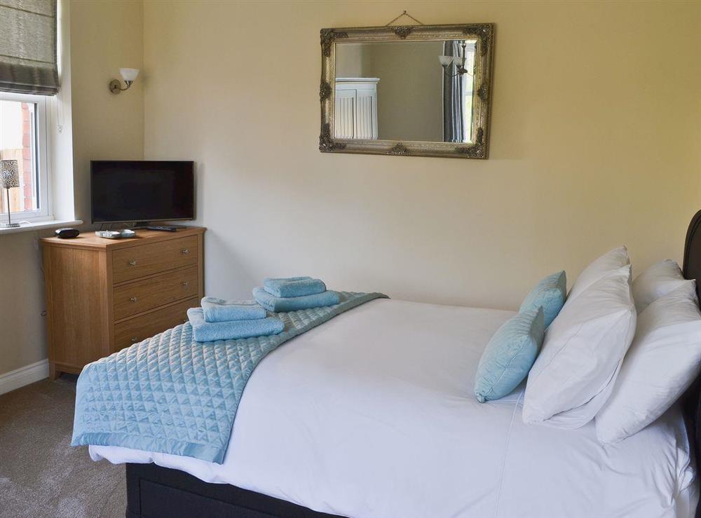 Double bedroom with 5ft bed, TV and seating area at Birchfield in Rhuallt, near St Asaph, Denbighshire