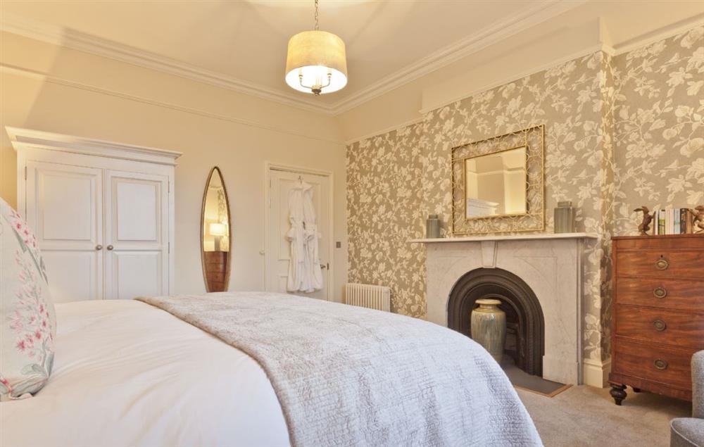 Bedroom with 6’ super king size zip and link bed and marble fireplace at Birkdale House, Windermere